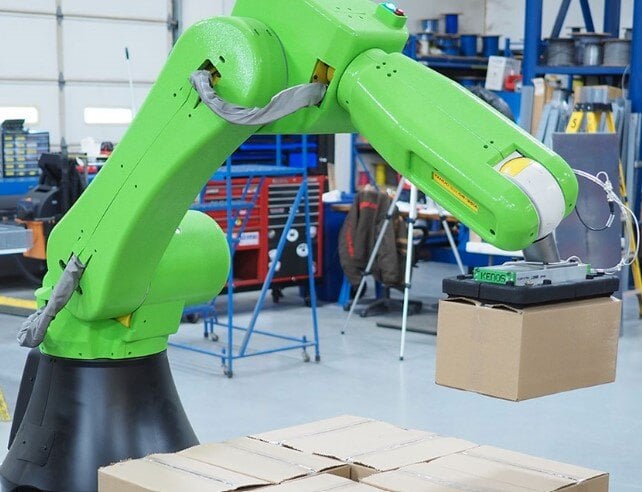 A green robot being used in a warehouse to increase efficency.